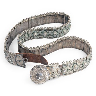 une vieille ceinture avec une boucle métallique sur fond blanc