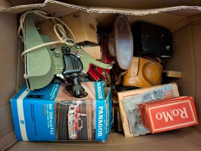 une boîte en carton remplie d'objets divers et une paire de chaussures