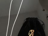 Collier Christian Lacroix posé sur une table, accompagné d'un sac en velours noir