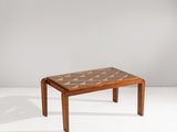 une petite table en bois dont le plateau est orné d'un motif géométrique