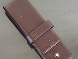 a brown leather wallet with a gold button on it