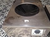 a silver stove top on a tiled floor in a kitchen
