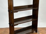a wooden book shelf with four shelves on top of it