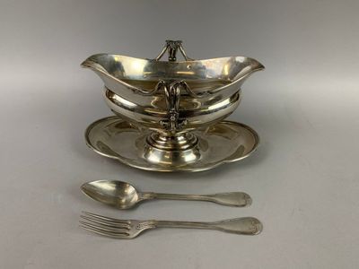une assiette en argent sur laquelle sont posées une cuillère et une autre cuillère