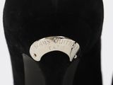 a close up of a pair of black high heels with a silver ring