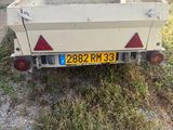 un petit camion blanc attelé à une remorque