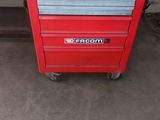 une boîte à outils rouge posée au milieu d'un garage
