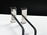 pair of metal bookends on a white surface with a black background