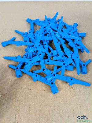 une pile de pinces à linge en plastique bleu posée sur une table