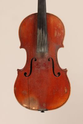 un vieux violon posé sur une surface blanche