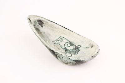 a spoon with a drawing on it sitting on a white surface