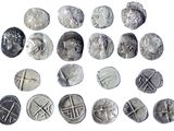 several different types of silver coins are shown on a white surface