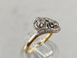 a close up of a gold and diamond ring on top of a clear glass