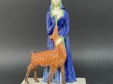 figurine of a woman and a dog on a pedestal