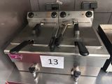 trois friteuses posées sur le plan de travail de la cuisine