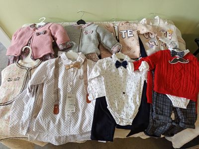 a couch that has a bunch of baby clothes on it