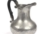 a silver pitcher that is sitting on a white surface