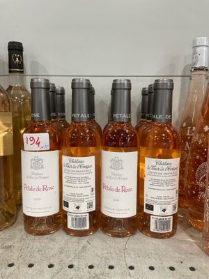 bottles of wine are lined up on a shelf in a store