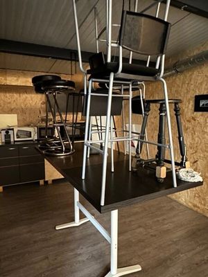 a black table with chairs and a black chair on top of it