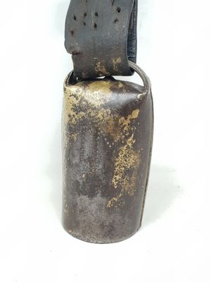 une cloche en métal avec une poignée noire sur fond blanc