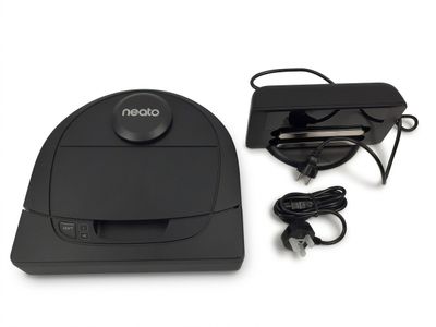 a black robot that is sitting next to a charger