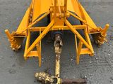 the front end of a yellow tractor is laying on the ground