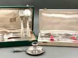 deux pièces d'argenterie dans un coffret vert posé sur une table