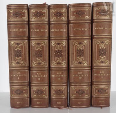 six old books are lined up in a row on a table