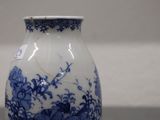 a blue and white vase sitting on a table