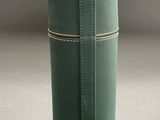 a green cylinder shaped box with a brown line on it