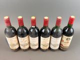 six bottles of wine lined up in a row on a table