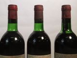 three bottles of wine are lined up in a row on a table