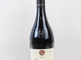 la bouteille de vin rouge est posée sur une surface blanche