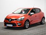 La voiture orange est garée sur un sol à damier dans une pièce.