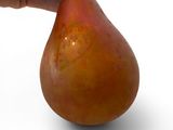 a hand that is holding a pear on a white surface