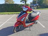 un scooter rouge garé sur un parking