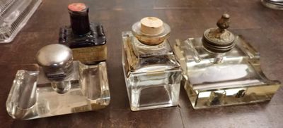 trois petites bouteilles en verre posées sur une table