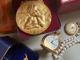 a box with a watch, a watch case, and other items on a table