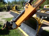 a close up of a construction vehicle that is parked in the grass