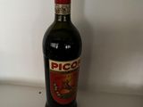 a bottle of alcohol sitting on a counter next to a plate of food