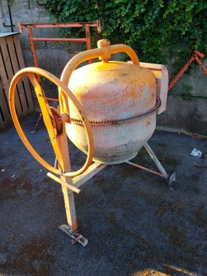 a cement mixer that is sitting on the ground