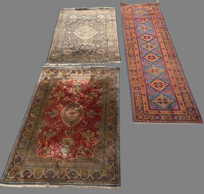 trois tapis orientaux sur fond gris