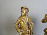 une statue représentant un homme tenant un fusil et un chien