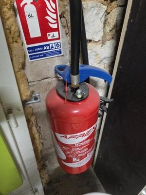 un extincteur à côté des toilettes dans une salle de bains