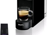 une machine à café noir avec une tasse de café à côté