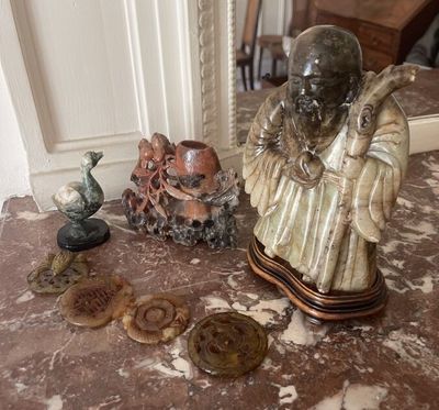 a statue of a man sitting on top of a table next to other items