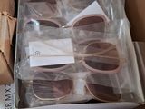 many pairs of sunglasses in a box on the floor