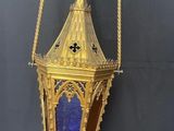 an antique brass and blue glass lantern hanging on a wall