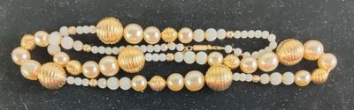 gold and white beaded bracelet with pearls on a black surface