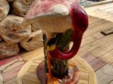a vase with a bird on it on a wooden table